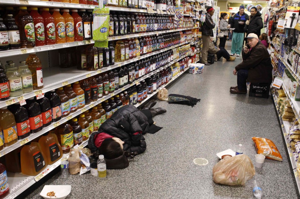 People rest at the aisle of a Publix grocery store after being stranded due to a snow storm in Atlanta
