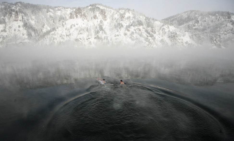 Members of a local winter swimming club Klyukin and Korabelnikov swim in the Yenisei River near Krasnoyarsk