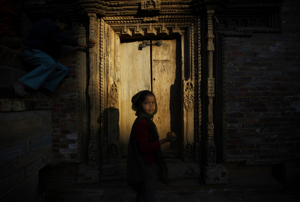 Evening light illuminates a girl playing at the Patan Durbar Square in Lalitpur