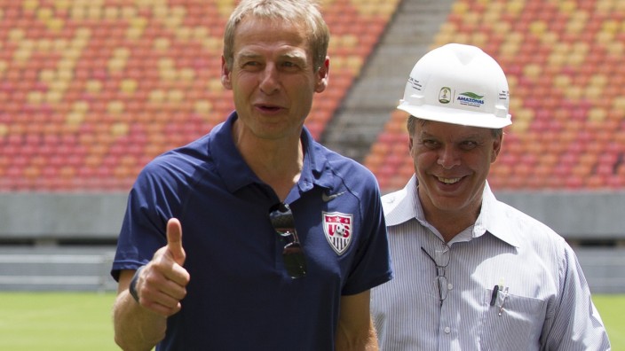 United States national soccer team coach Klinsmann of Germany gestures to photographers while visiting Arena Amazonia stadium with Monteiro in Manaus