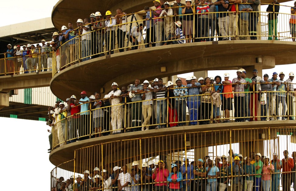 Miners gather to mourn their colleagues outside a shaft at Harmony Gold's Doornkop mine near Johannesburg