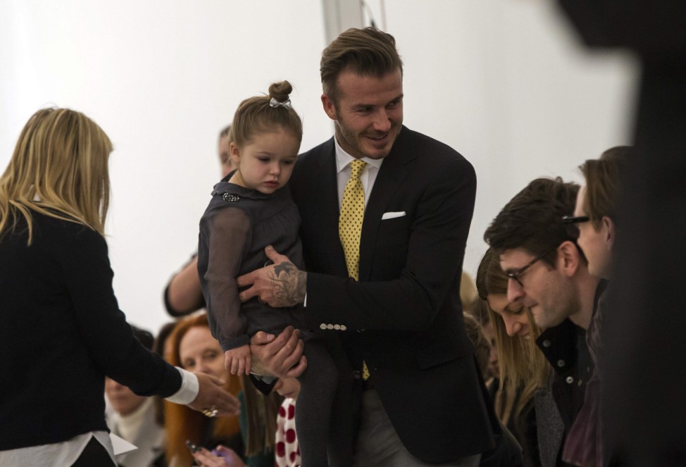 David Beckham holds his daughter Harper before the Victoria Beckham Fall 2014 collection during New York Fashion Week