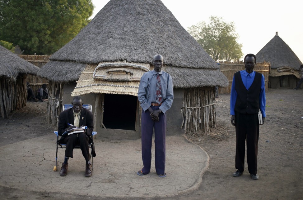 Men wait for Sunday mass near a church at a village in a rebel-controlled territory in Upper Nile State