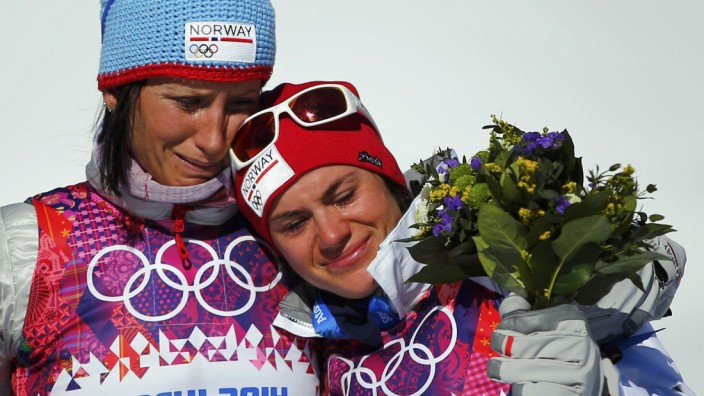 Norway's Bjoergen and Weng cry as they celebrate after women's cross-country skiathlon event at 2014 Sochi Winter Olympics