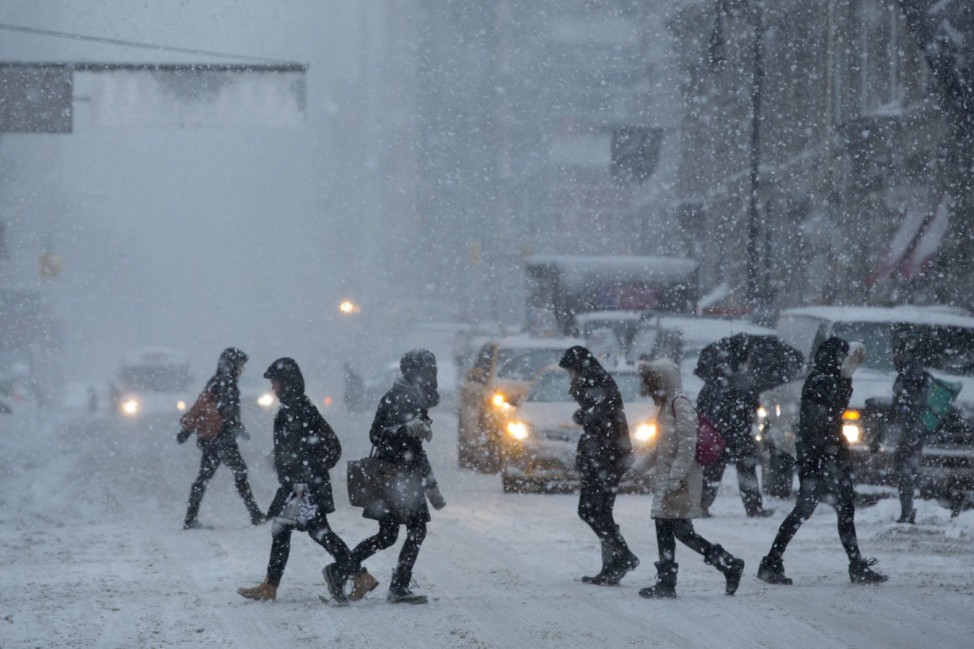Commuters cross Broadway through heavy snow in Manhattan, New York