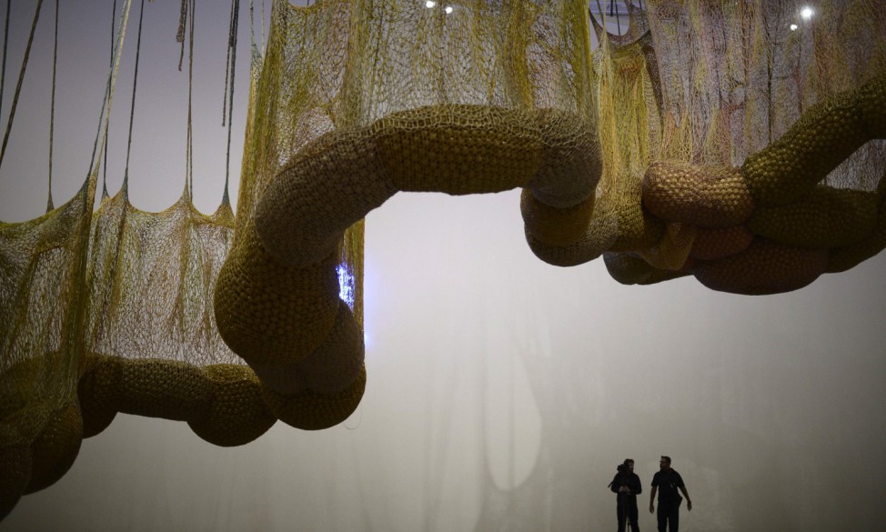 Visitors stand under 'Life Is A Body We Are Part Of', a giant biomorphic sculpture that forms part of a retrospective of the work of Brazilian artist Ernesto Neto, at the Guggenheim Museum in Bilbao