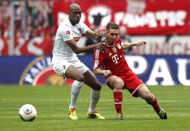 Bayern Munich's Lahm tackles Freiburg's Fernandes during their German Bundesliga first division soccer match in Munich
