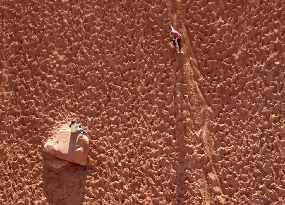 An aerial view Deanna Irvin as sledboards past her mother Mary Irvin on a sand hill outside Moab Utah