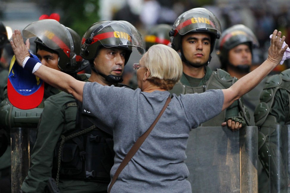 An opposition supporter shouts at a riot police officer during a protest against President Nicolas Maduro's government in Caracas