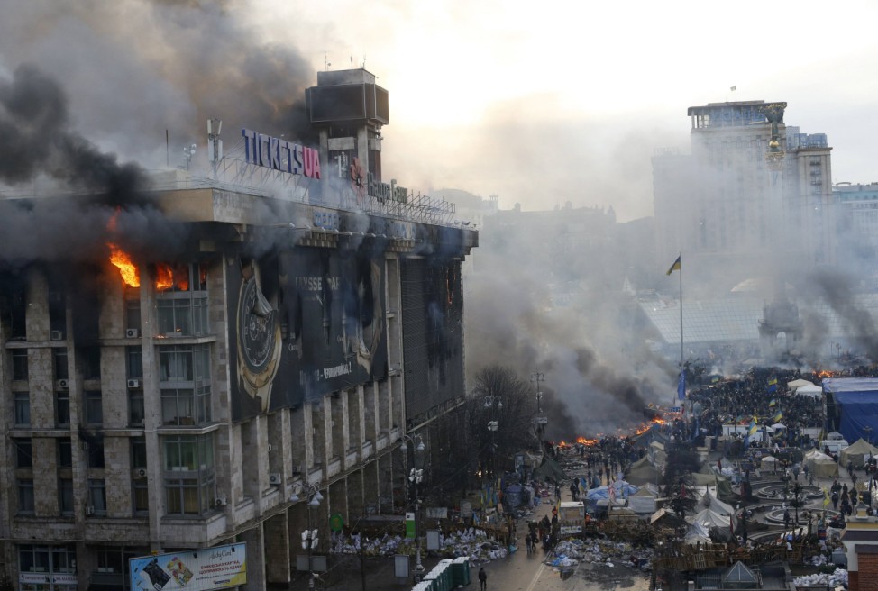 A trade union building is seen on fire in Independence Square during clashes in central Kiev