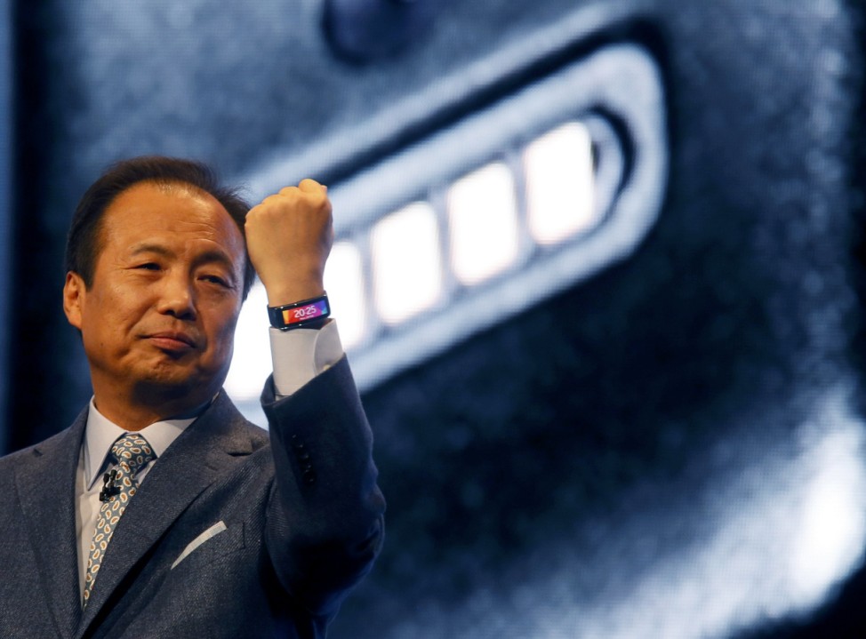 JK Shin, President and Head of IT and Mobile Communication Division of Samsung Electronics, wears the company's new Gear Fit fitness band during its launching ceremony at the Mobile World Congress in Barcelona