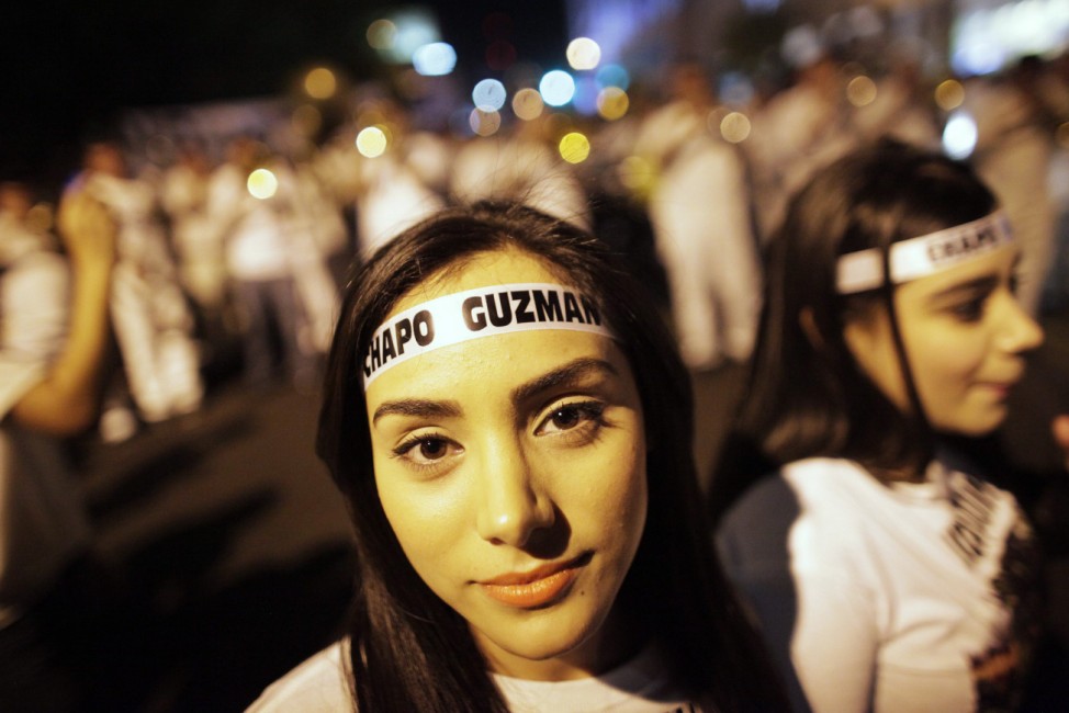 Young women wear headbands featuring the name of Chapo Guzman during a march in Culiacan