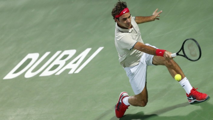 Federer of Switzerland hits a return to Rosol of the Czech Republic during their men's singles match at the ATP Dubai Tennis Championships