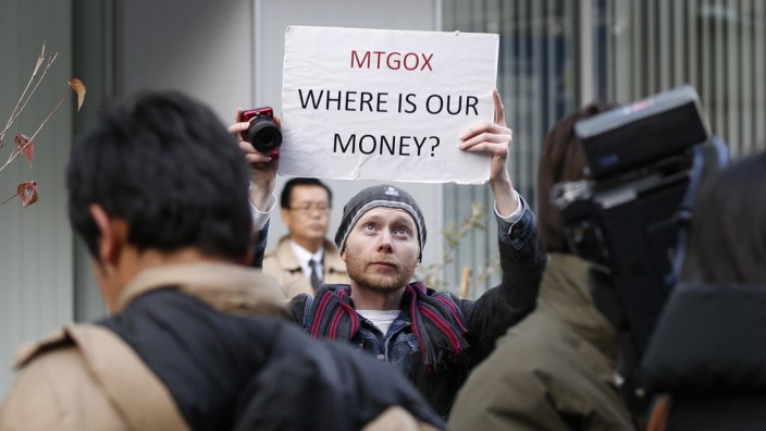 Burges, a self-styled cryptocurrency trader and former software engineer from London, holds up a placard to protest against Mt. Gox in Tokyo