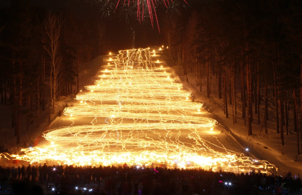 Spectators watch hundreds of skiers descending down from the slope while holding lit torches in the town of Zheleznogorsk, some 50km (31 miles) northeast of Russia's Siberian city of Krasnoyarsk
