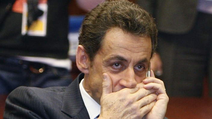 File photo of French President Sarkozy who makes a phone call at the start of a meeting on the second day of a European Union leaders summit in Brussels
