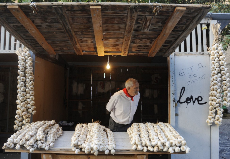 A garlic seller looks out from his stall during the start of the San Fermin festival in Pamplona