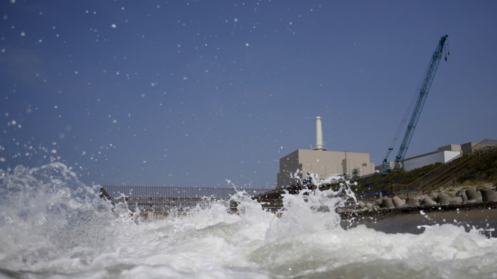 Chubu Electric Power Co.'s Hamaoka Nuclear Power Station is seen behind waves at a beach in Omaezaki