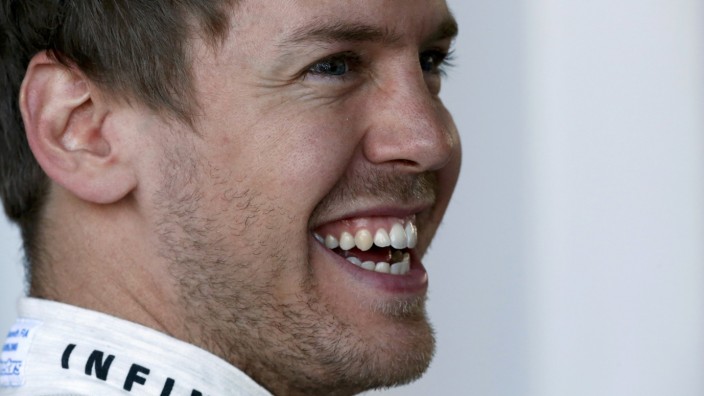 Red Bull Formula One driver Vettel of Germany smiles in the garage during the first practice session of the Australian F1 Grand Prix in Melbourne