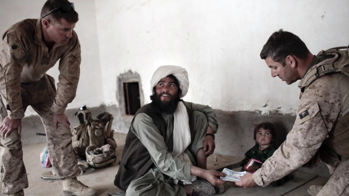 Afghanische Helfer der Bundeswehr: Es sind Einheimische, auf die die Nato in Afghanistan oft vor Ort angewiesen ist und die mit dieser Zusammenarbeit ihr Leben riskieren. Auf dem Bild schaut ein afghanischer Imam zu einem Landsmann, der ihm im Gespräch mit den US-Soldaten übersetzt - und dabei unfotografiert bleibt.