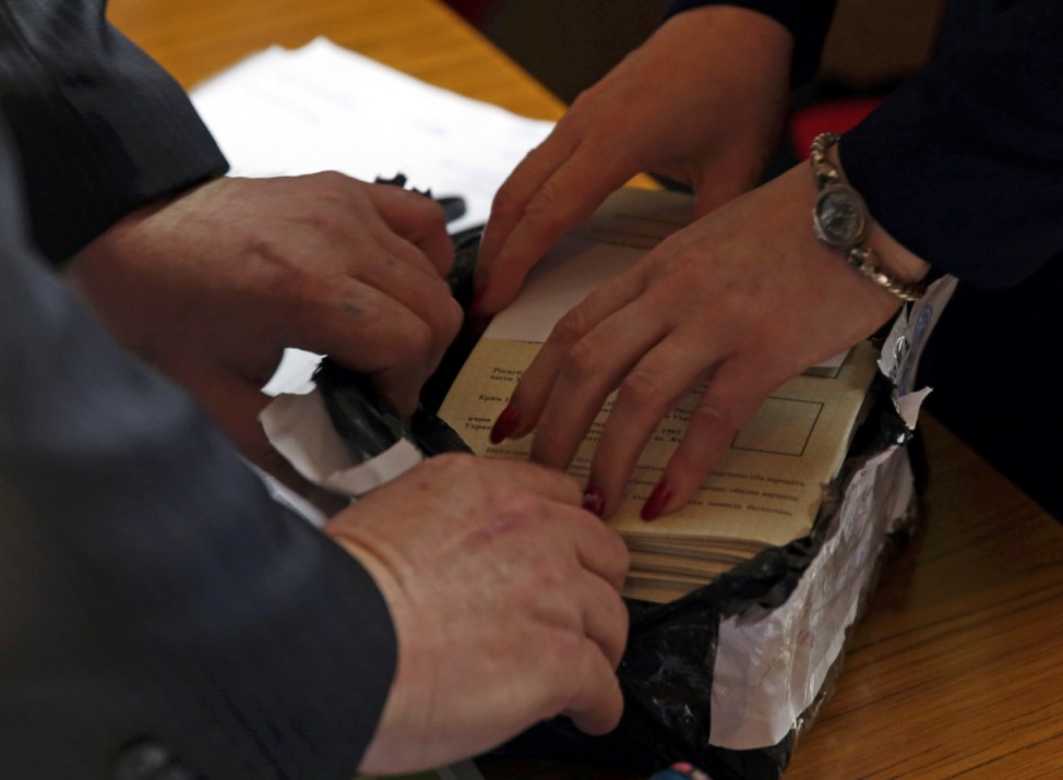 Officials open a package with ballots during the referendum on the status of Ukraine's Crimea region at a polling station in Sevastopol