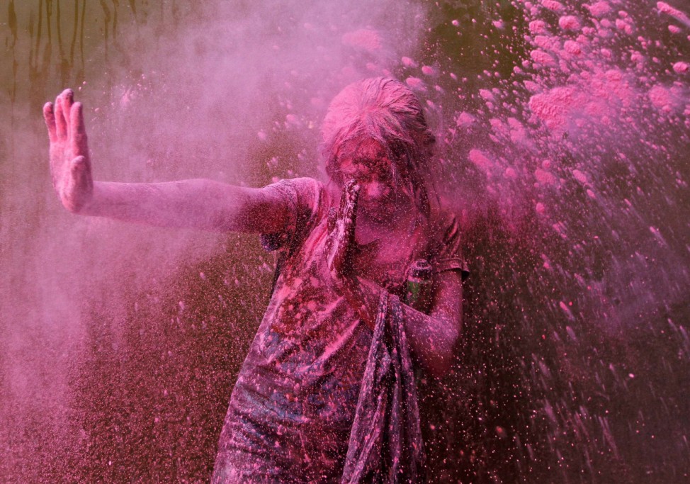 A girl smeared with colours reacts during Holi celebrations in Chennai