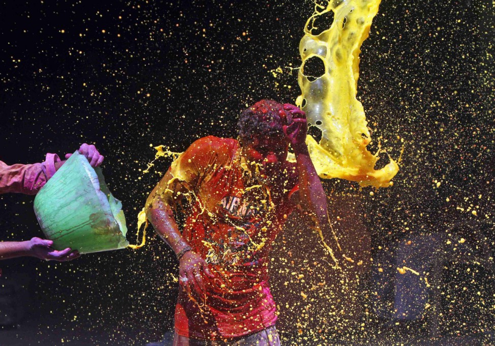 A man reacts to coloured water being splashed over him during Holi celebrations in Chennai
