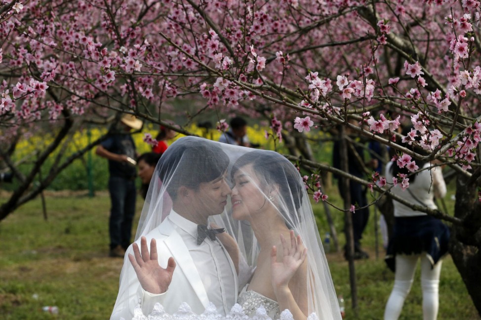 A couple pose for wedding pictures at a park in Wenzhou
