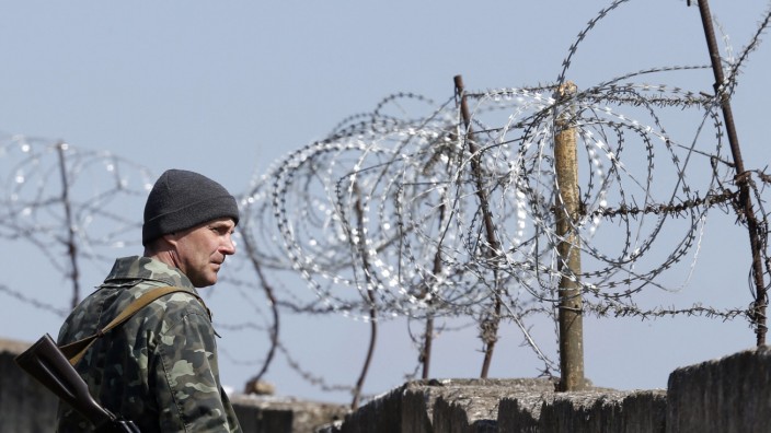 A Ukrainian serviceman stands guard at a Ukrainian military base in the Crimean town of Belbek