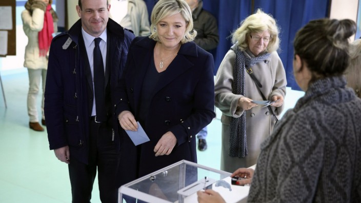 France's far-right National Front political party leader Marine Le Pen prepares to cast her ballot at a polling station during the first round in the French mayoral elections in Henin Beaumont