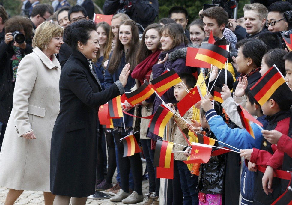 Liyuan wife China's President Xi and Schadt partner of German President Gauck greet well wishersat Bellevue presidential palace in Berlin