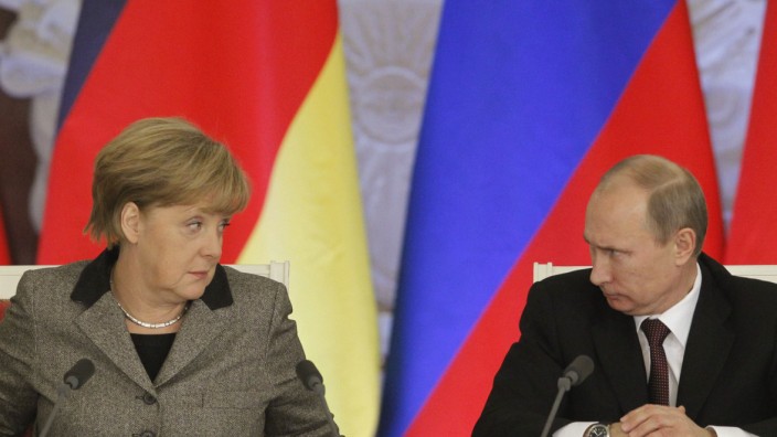 File photo of Russian President Putin and German Chancellor Merkel answering journalists' questions during a joint news conference in Moscow's Kremlin
