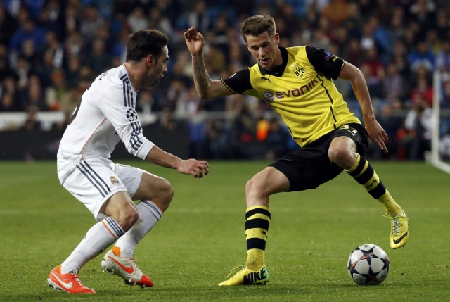 Carvajal of Real Madrid challenges Durm of Borussia Dortmund during their Champions League quarter-final first leg soccer match at Santiago Bernabeu stadium in Madrid