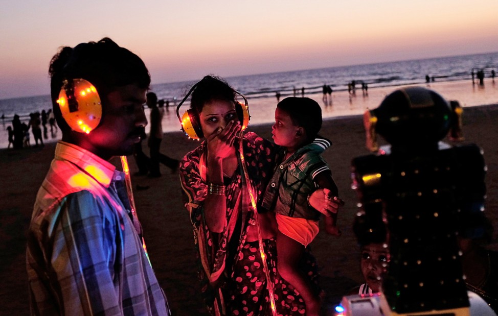 A woman reacts as she listens to a fortune telling machine at a beach along the Arabian Sea in Mumbai