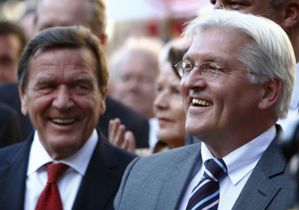 German Foreign Minister and candidate for chancellor of the SPD Steinmeier smiles besides former Chancellor Schroeder during election campaign rally in Hanover