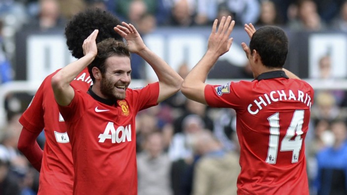 Manchester United's Mata celebrates with Hernandez after scoring a goal against Newcastle United during their English Premier League soccer match at St James' Park in Newcastle