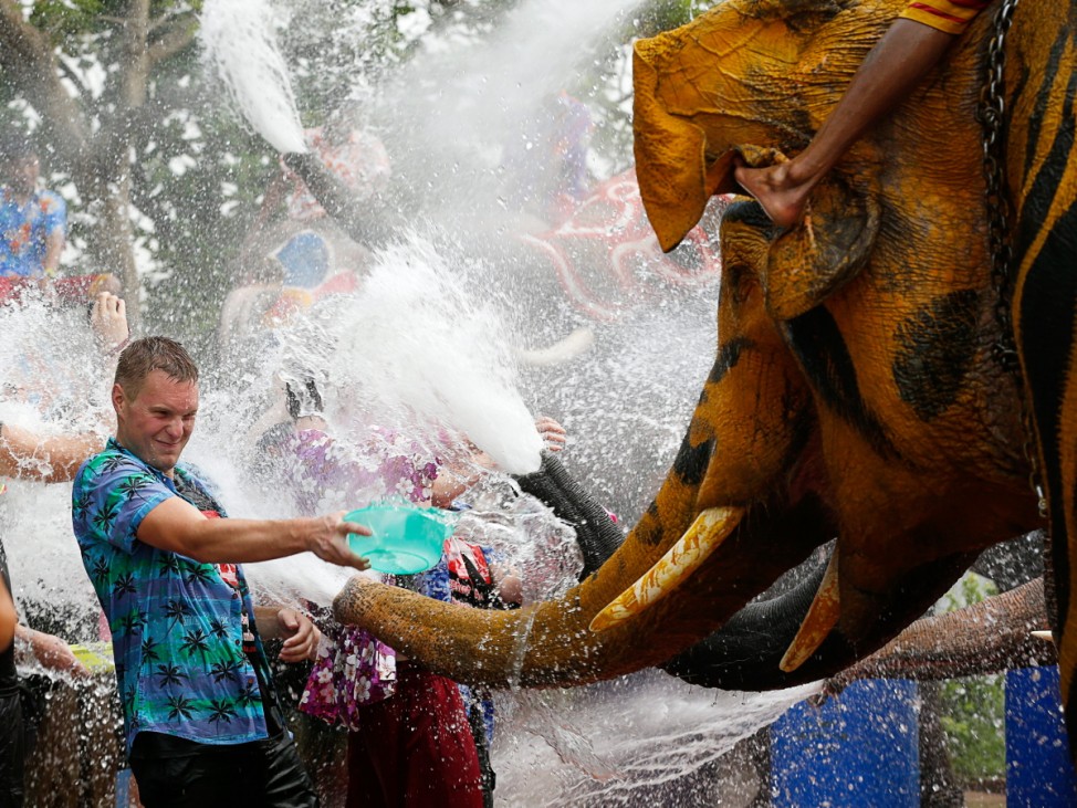 Thai elephant spray water at tourists to celebrate Songkran festi