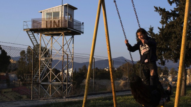 Children play in a park next to a fence marking the United Nations buffer zone in a partially restricted area in the Turkish Cypriot controlled area of central Nicosia