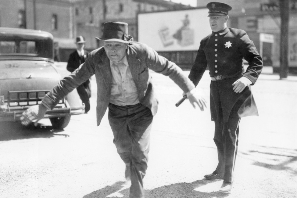 Polizist verfolgt einen Mann während eines Streiks in San Francisco, 1934