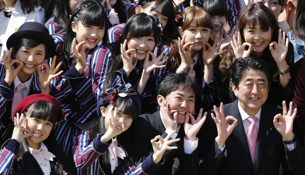 Japan's PM Abe poses with entertainment celebrities including members of girls' pop group HKT48, led by Sashihara, at a cherry blossom viewing party at Tokyo's Shinjuku Gyoen park