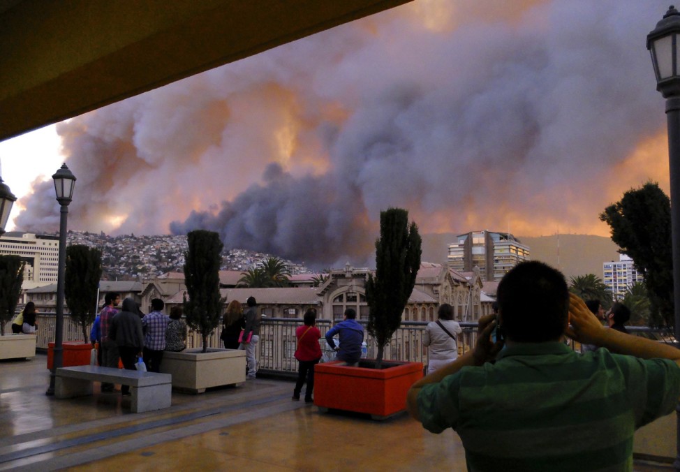 People look at smoke from a forest fire in Valparaiso city, northwest of Santiago