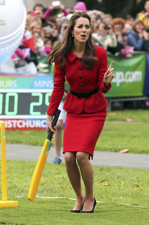 Catherine, the Duchess of Cambridge, reacts as she holds a cricket bat during a promotional event she attended with her husband, Britain's Prince William, for the upcoming Cricket World Cup in Christchurch
