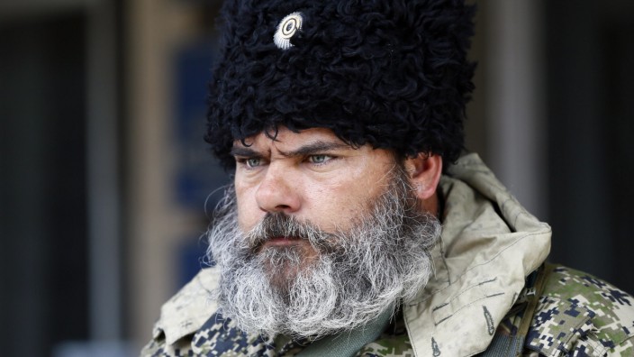 A pro-Russian armed man looks on near the mayor's office in Slaviansk