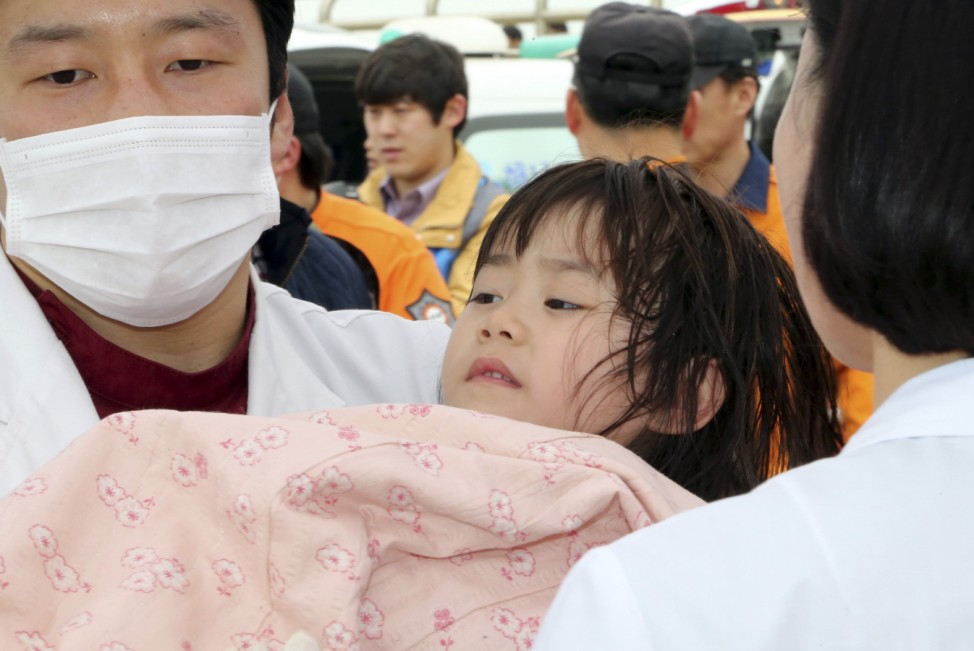 A girl rescued by South Korean maritime policemen from a sinking ship 'Sewol' in the sea off Jindo, is treated at a port in Jindo