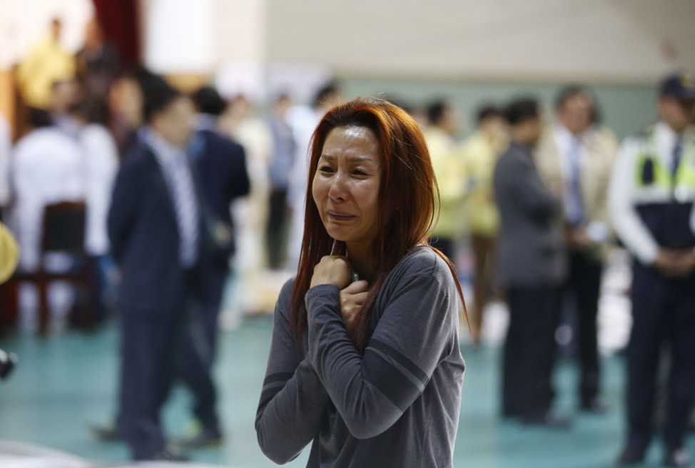 The mother of a passenger who was on a sinking ferry reacts as she finds his son at a gym where rescued passengers gather in Jindo