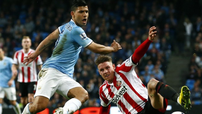 Manchester City's Aguero challenges Sunderland's Wickham during their English Premier League soccer match at the Etihad stadium in Manchester