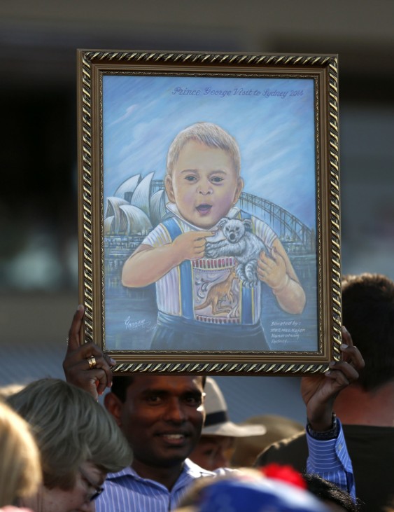 A man holds a painting of Britain's Prince George at Manly beach in Sydney