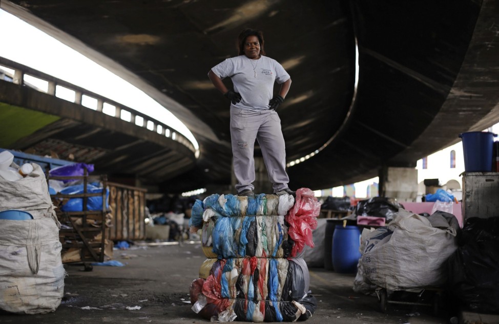 Garbage recycler Maria Aparecida poses on a bundle of plastics to be recycled under the Glicerio viaduct in Sao Paulo