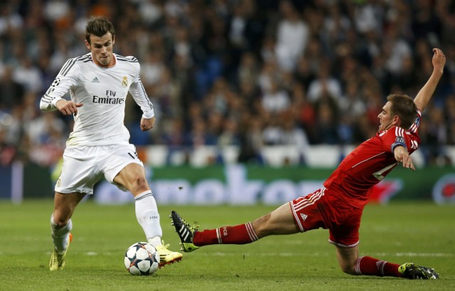 Real Madrid's Gareth Bale is challenged by Bayern Munich's Philipp Lahm during their Champions League semi-final first leg soccer match at Santiago Bernabeu stadium in Madrid