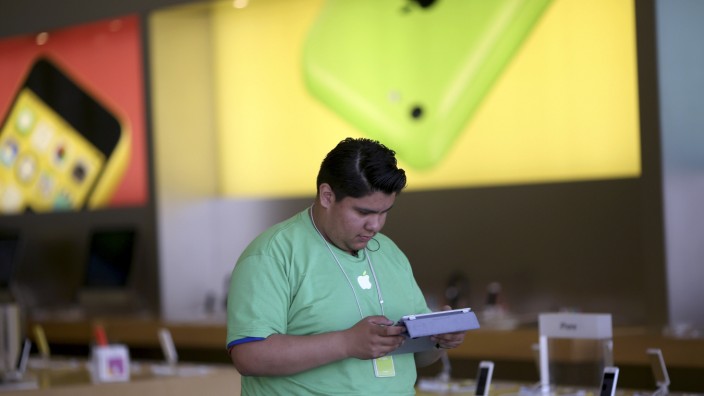 An Apple employee works in a retail store in the Marina neighborhood in San Francisco